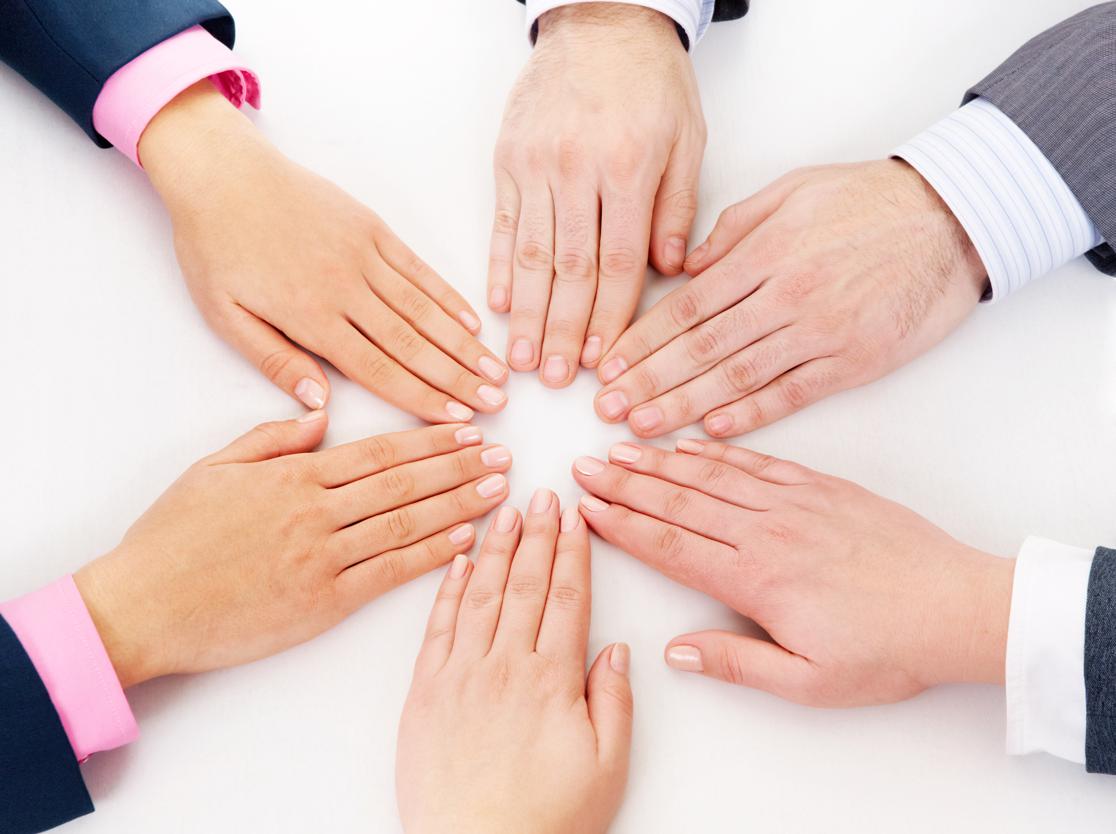 A team of employees with their hands clasped